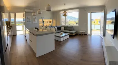 a kitchen and living room with a couch and a table at SimplyCity Homestay Apartment 1 in Kremasti