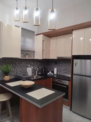 a kitchen with white cabinets and a black counter top at Melograno di Rodi 4 in Rhodes Town
