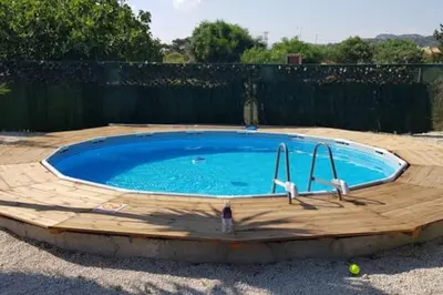 a large pool with a wooden deck around it at Cavo Prima Kiotari in Gennadi