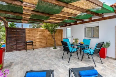 a patio with a table and chairs and a wooden ceiling at Cavo Prima Kiotari in Gennadi