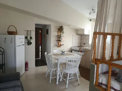 a kitchen with a white table and white chairs at Cavo Prima Kiotari in Gennadi
