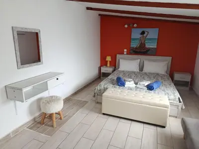 a bedroom with a white bed and a desk at Cavo Prima Kiotari in Gennadi