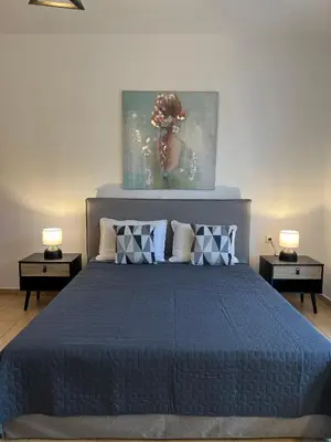 a bedroom with a blue bed with two night stands at Elefanti Nani in Livadia