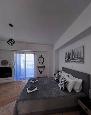 a bedroom with a large bed and a window at Elefanti Nani in Livadia