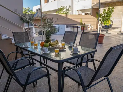 a table with a bowl of fruit and glasses of orange juice at Villa Nektarina in Afantou