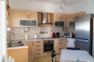a kitchen with wooden cabinets and a stainless steel refrigerator at Villa Nektarina in Afantou