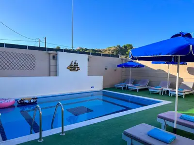 a swimming pool with a patio and an umbrella at Villa Nektarina in Afantou