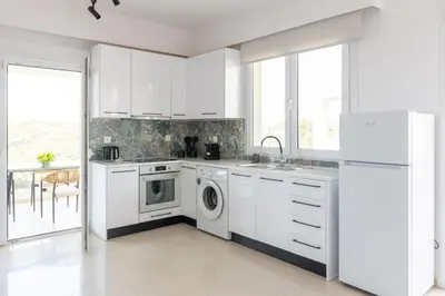 a kitchen with white cabinets and a dishwasher at Island Hills in Rhodes Town