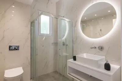 a bathroom with a shower and a sink and a mirror at Island Hills in Rhodes Town