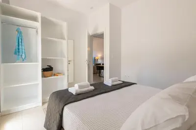 a white bedroom with a bed with two towels on it at Island Hills in Rhodes Town
