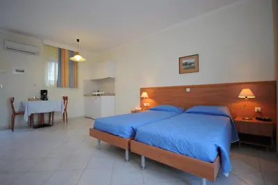 a bedroom with a large bed with blue sheets at Golden View Studios in Líndos