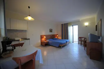 a living room with a blue bed and a kitchen at Golden View Studios in Líndos