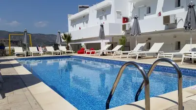 a hotel with a swimming pool in front of a building at Golden View Studios in Líndos