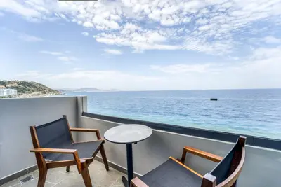 a balcony with two chairs and a table and the ocean at Island Sea Side Hotel - Adults Only in Rhodes Town