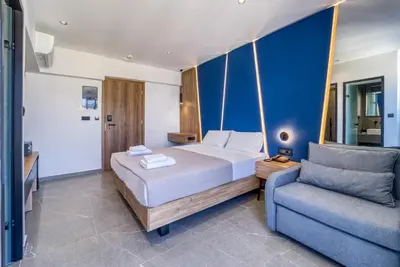 a bedroom with a bed and a blue wall at Island Sea Side Hotel - Adults Only in Rhodes Town