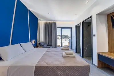 a bedroom with a large bed with blue walls at Island Sea Side Hotel - Adults Only in Rhodes Town