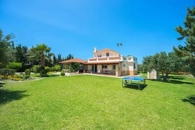 a house with a large yard with a bench in it at Villa Amelia in Gennadi