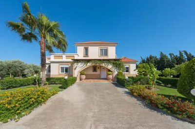 a house with a palm tree and a driveway at Villa Amelia in Gennadi