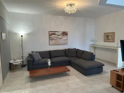 a living room with a couch and a table at Christos Apt - City Center w/ Royal Garden View in Rhodes Town