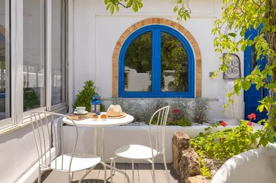 a table and chairs on a patio with a window at Hotel Nathalie in Ixia