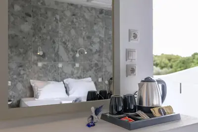 a hotel room with a bed and a mirror at Hotel Nathalie in Ixia