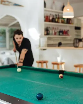 a man playing a game of pool with a cue at Hotel Nathalie in Ixia