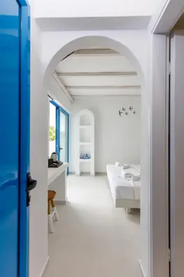 an archway in a white room with a table at Hotel Nathalie in Ixia