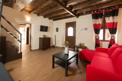 a living room with a red couch and a table at Xenios Zeus Maisonettes Old Town Rhodes in Rhodes Town