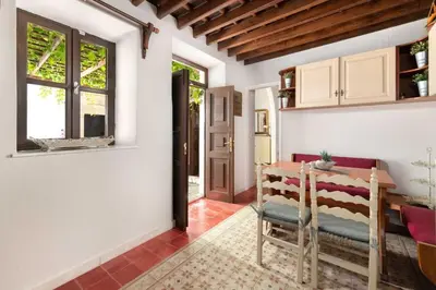 a living room with a table and a chair at Lindos Villa Petra with Acropolis View in Líndos