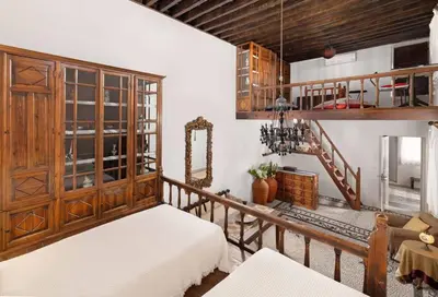 a living room with two beds and a staircase at Lindos Villa Petra with Acropolis View in Líndos