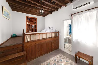 a bedroom in a villa with a bed and a window at Lindos Villa Petra with Acropolis View in Líndos