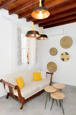 a living room with a white couch and two tables at Pera houses 2-bedroom in the center of Lindos in Líndos