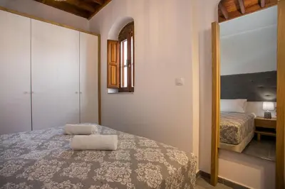 a bedroom with a bed with a mirror and a bed at Pera houses 2-bedroom in the center of Lindos in Líndos