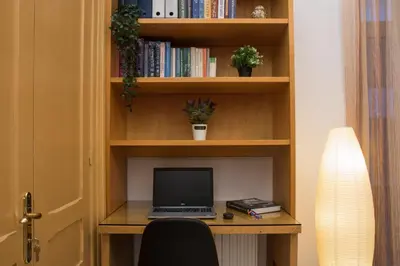 a laptop computer sitting on a desk in a book shelf at Niochori Heritage: The Mermaid Suite in Rhodes Town