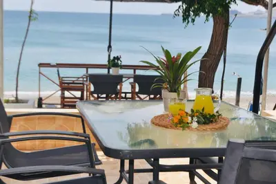 a table with two glasses of juice and flowers on it at Maroulitsas Sea Esta 1 in Haraki