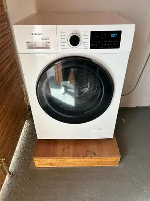 a white washing machine sitting on a wooden shelf at Maroulitsas Sea Esta 2 in Haraki