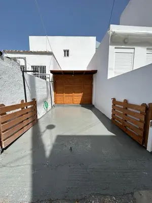 a garage with a wooden door on the side of a building at Maroulitsas Sea Esta 2 in Haraki