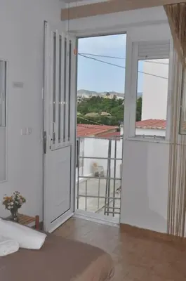 a bedroom with a door open to a balcony at Maroulitsas Sea Esta 2 in Haraki