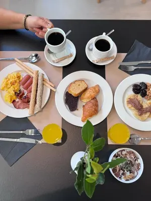 a table with plates of breakfast food and two cups of coffee at Angela Downtown Hotel in Rhodes Town