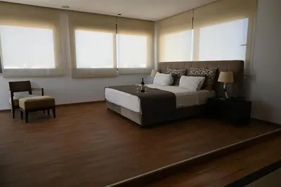 a bedroom with a bed and a chair and windows at Angela Downtown Hotel in Rhodes Town
