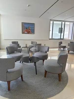 a waiting room with chairs and tables and a white wall at Angela Downtown Hotel in Rhodes Town