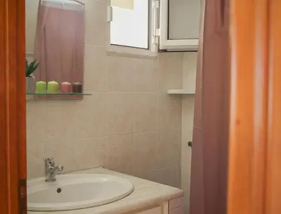 a bathroom with a sink and a mirror at Beautiful penthouse studio for 2 in Archangelos