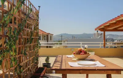a wooden table with a bowl of fruit on a patio at Beautiful penthouse studio for 2 in Archangelos