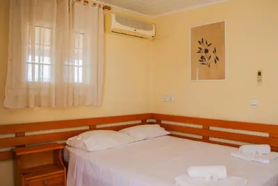 a bedroom with two beds and a window at Beautiful penthouse studio for 2 in Archangelos