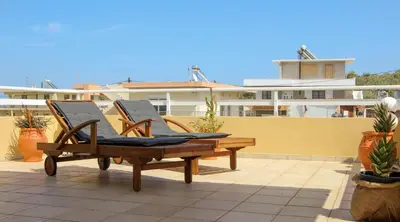 a pair of chairs sitting on a patio at Beautiful penthouse studio for 2 in Archangelos
