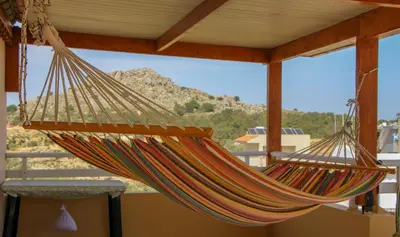 a hammock hanging from a roof with a view at Beautiful penthouse studio for 2 in Archangelos