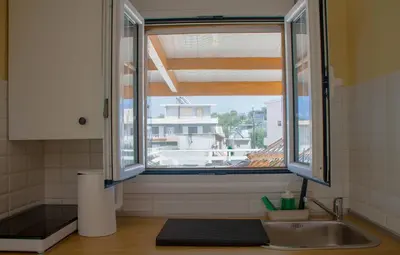 a kitchen with a sink and a window at Beautiful penthouse studio for 2 in Archangelos