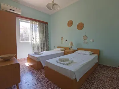 a hotel room with two beds and a window at Beautiful apartment with 3 bedrooms in Archangelos