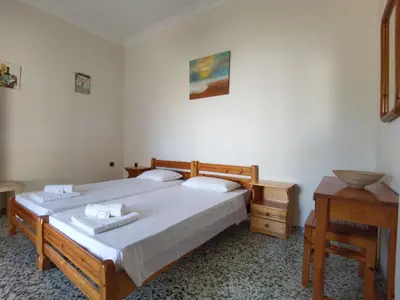 a bedroom with two twin beds and a table at Beautiful apartment with 3 bedrooms in Archangelos