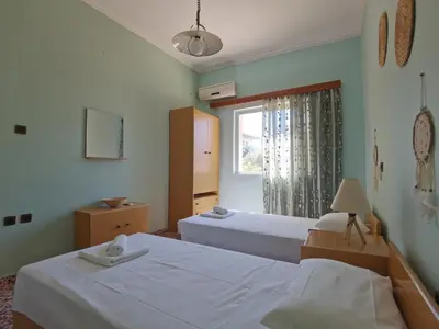 a bedroom with two beds and a window at Beautiful apartment with 3 bedrooms in Archangelos